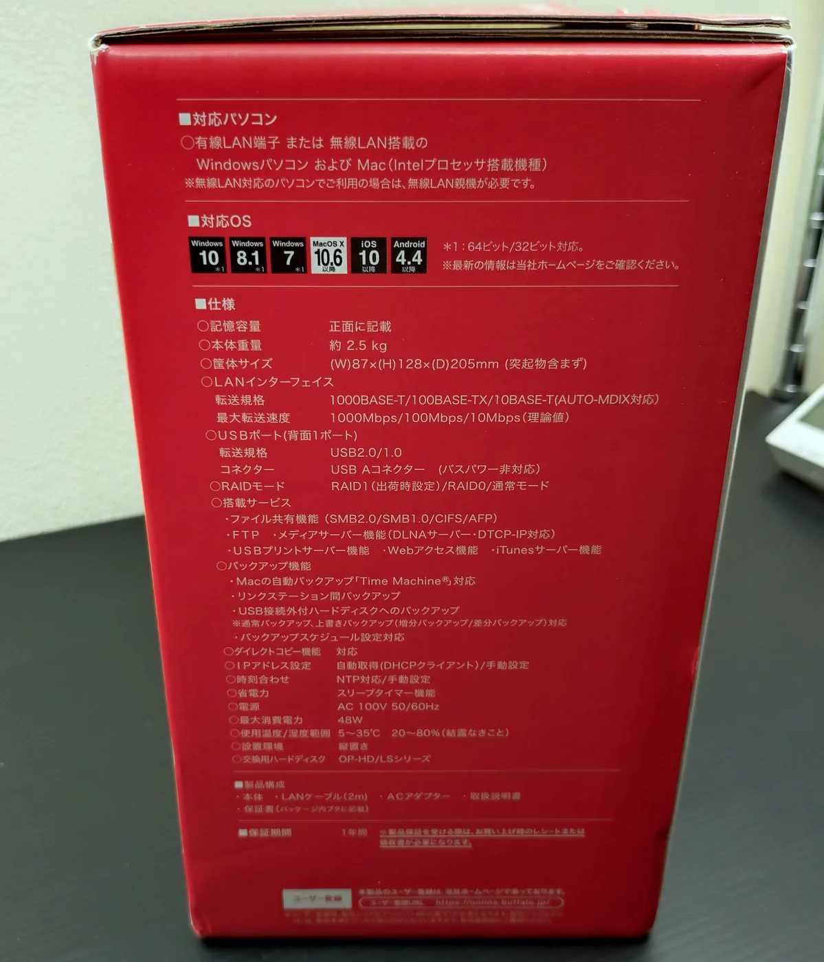 LS220D0802Gの化粧箱裏面にある赤地の仕様パネル。対応OS、筐体サイズ、最大転送速度、RAIDモード、搭載サービス、最大消費電力などが印刷されている