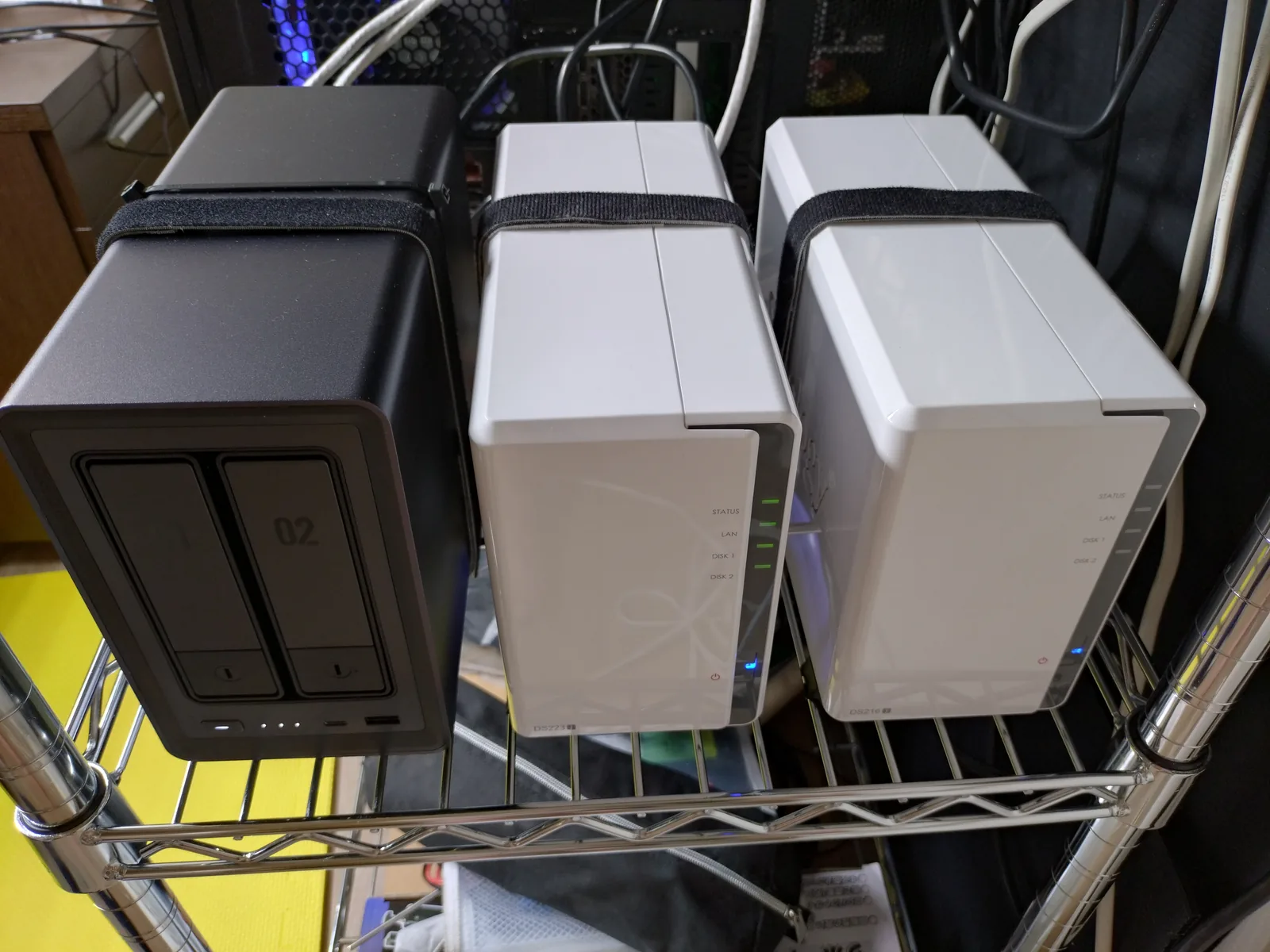 メタルラックに並べた2ベイNAS 3台。左からUGREEN NASync DXP2800、Synology DS223j、Synology DS216j（2025年8月撮影）